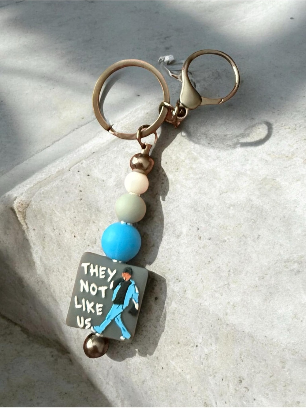Handmade Blue & Gray Beaded Keychain - "They Not Like Us" Design